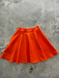 Harper orange pleated skater skirt with pockets made of vibrant smooth slightly shiny fabric and elastic waistband