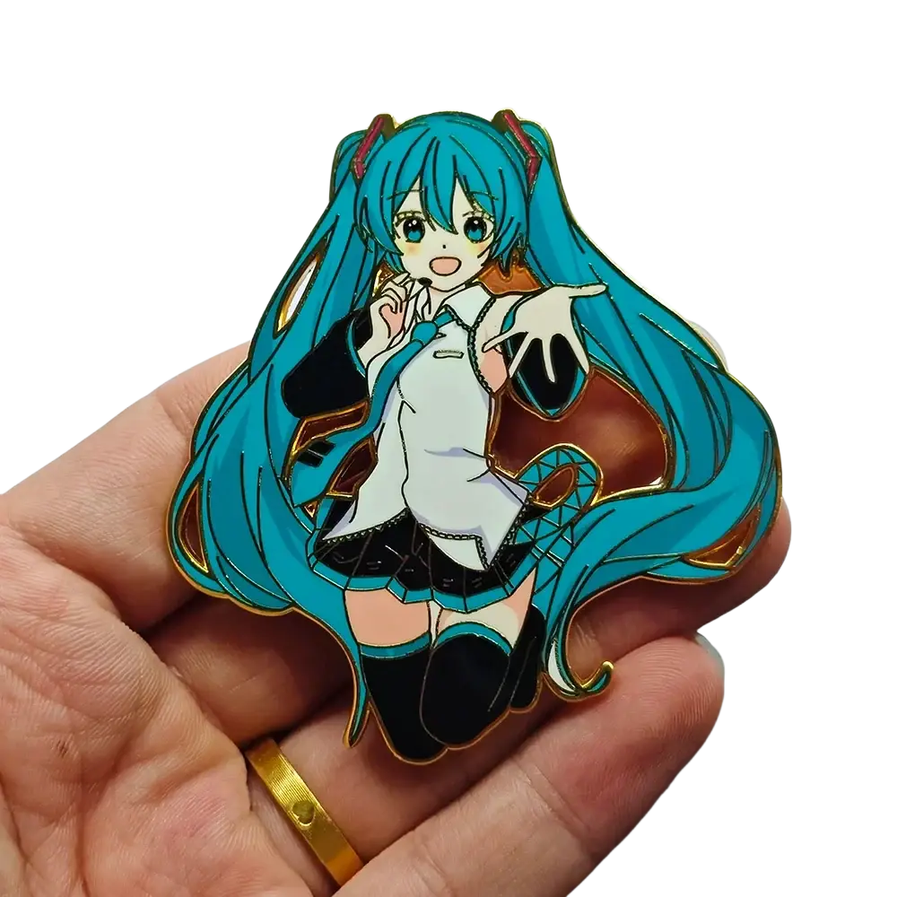 Hatsune Miku anime enamel pin with vibrant turquoise hair, white blouse, black skirt, and gold-trimmed thigh-high socks