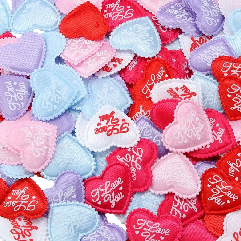 A collection of pastel and vibrant heart shaped fabric patches with embroidered i love you text for valentine parties