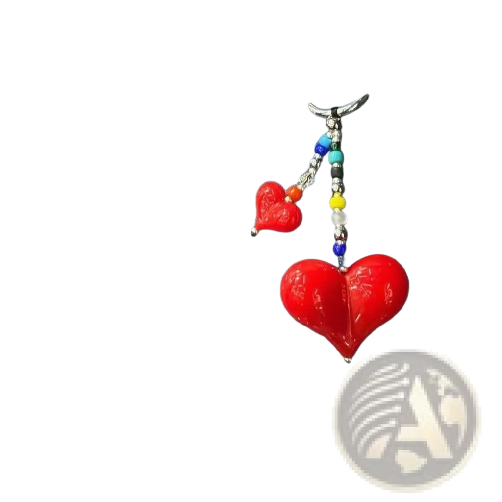 Vibrant red heart-shaped glass charm with colorful beaded chain hanging from denim handbag as bag charm