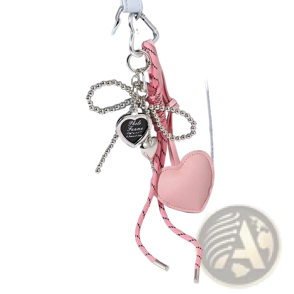 Pink heart pendant keychain bag accessory in leather with silver frame and beaded chain on light blue handbag