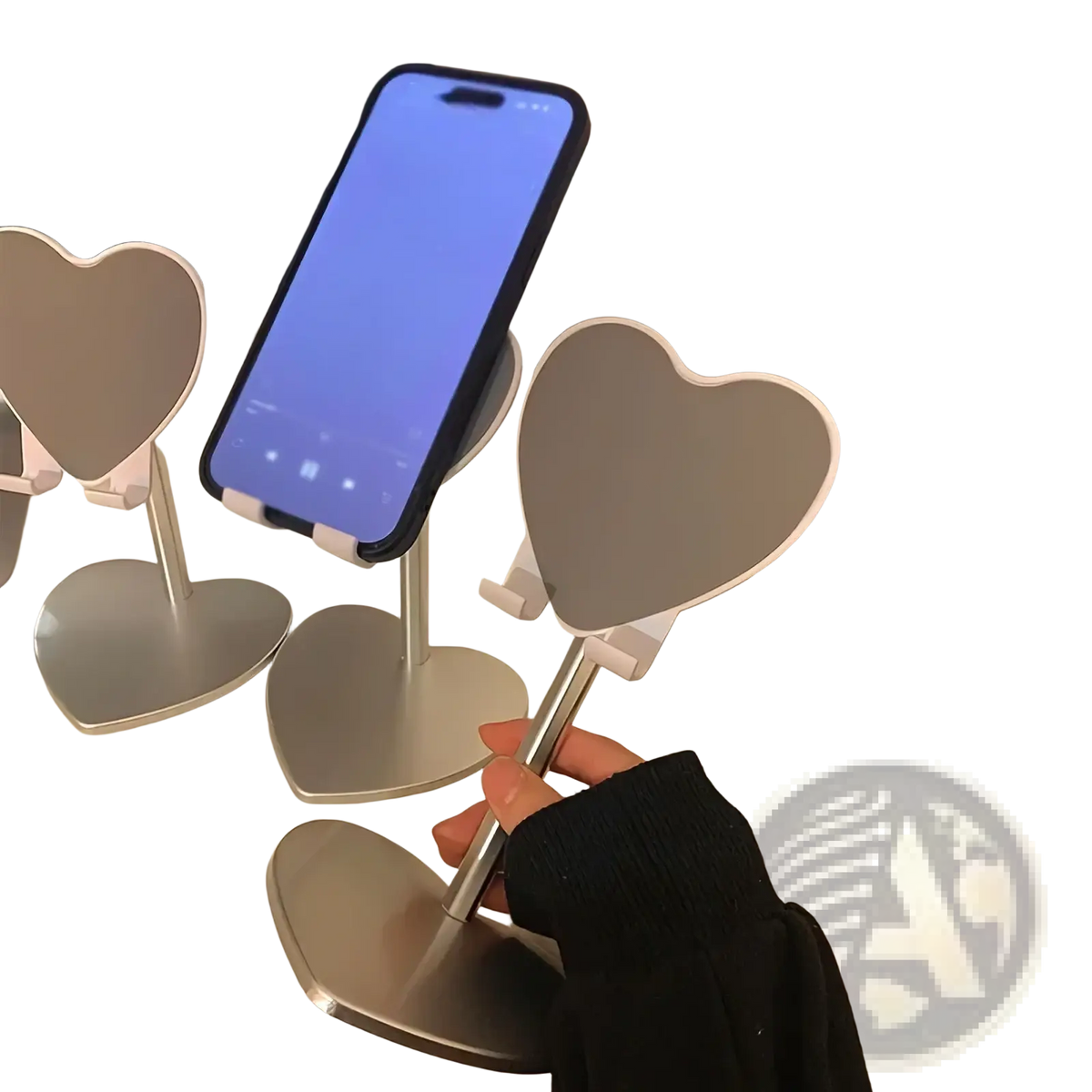 Silver heart shaped adjustable phone stand made of metal holding a smartphone on a desktop holder