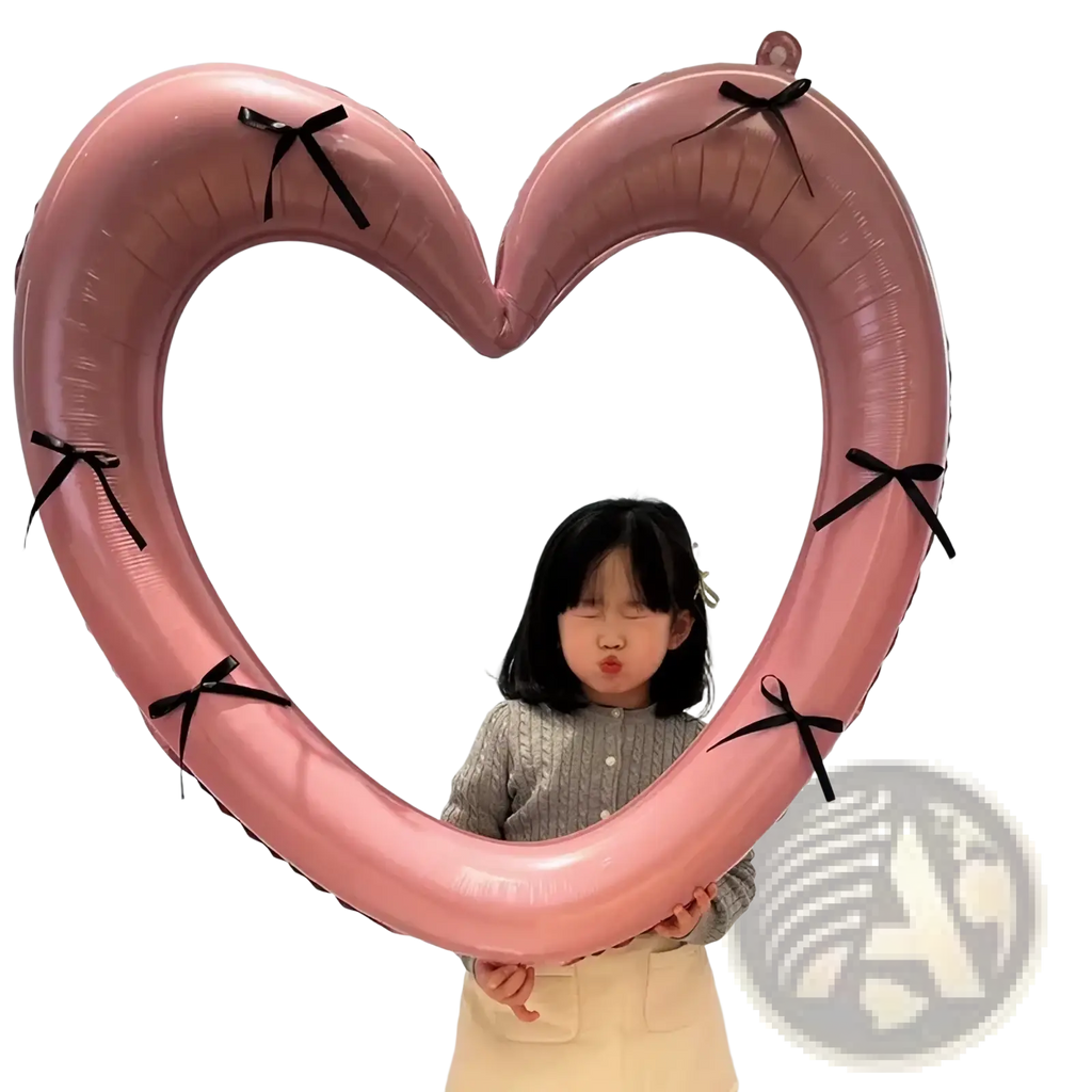 A pink heart-shaped balloon with black ribbon ties used as a heart photo frame balloon party decoration