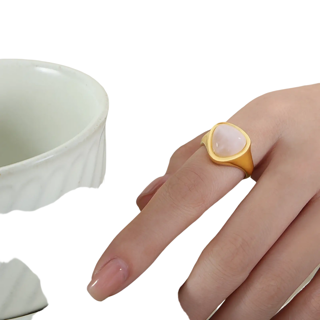 Gold ring with a soft pink heart-shaped natural stone set in a sleek titanium steel signet band
