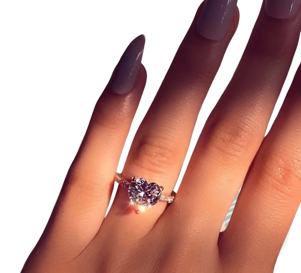 A sparkling heart shaped zircon engagement ring with white gold plating elegantly worn on a finger