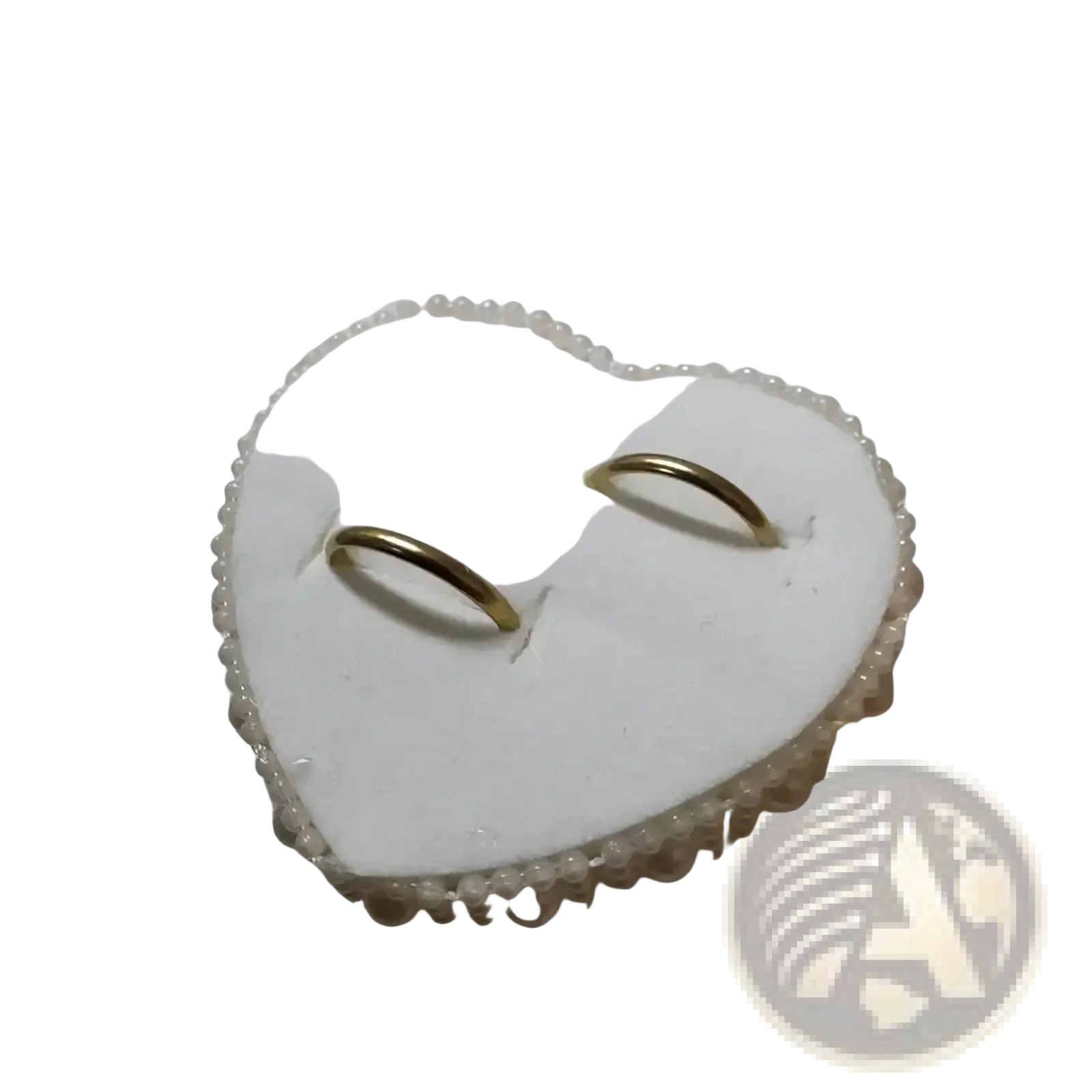 Heart wedding ring pillow in white with pearl trim and satin ribbon holding two gold wedding bands for bridal ceremony