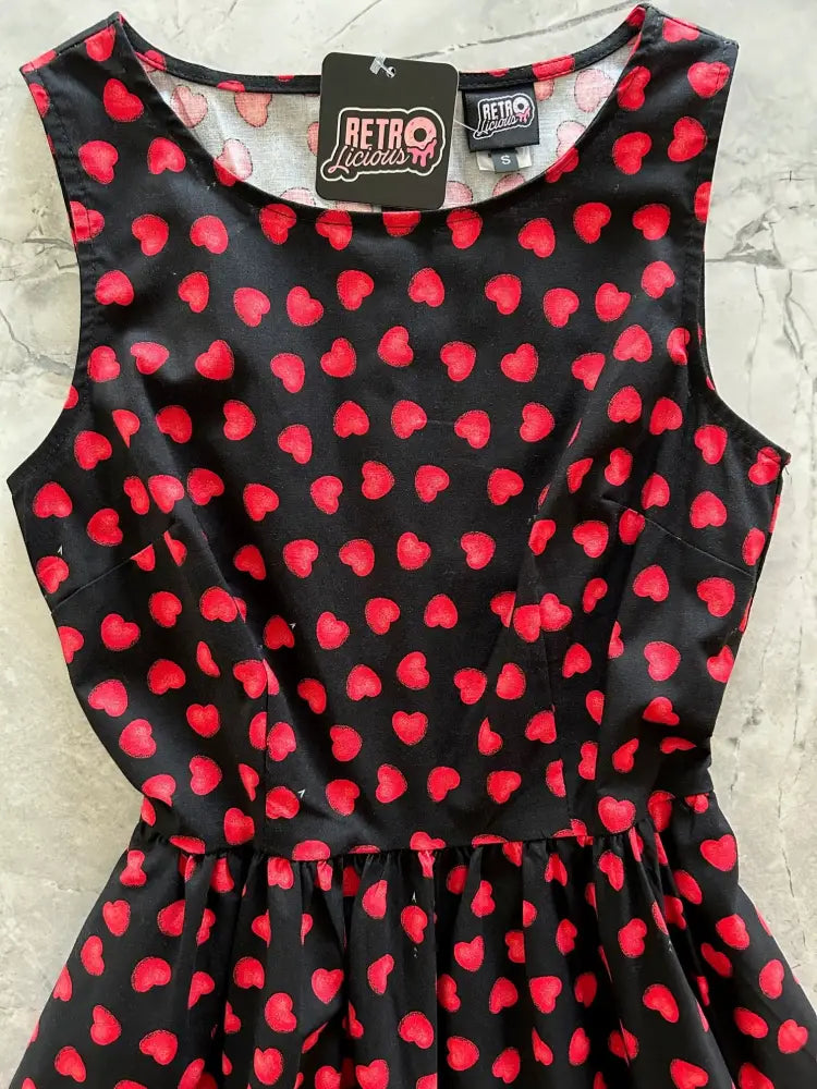 Black sleeveless vintage style cotton midi dress with red heart print fitted bodice and flared skirt with pockets