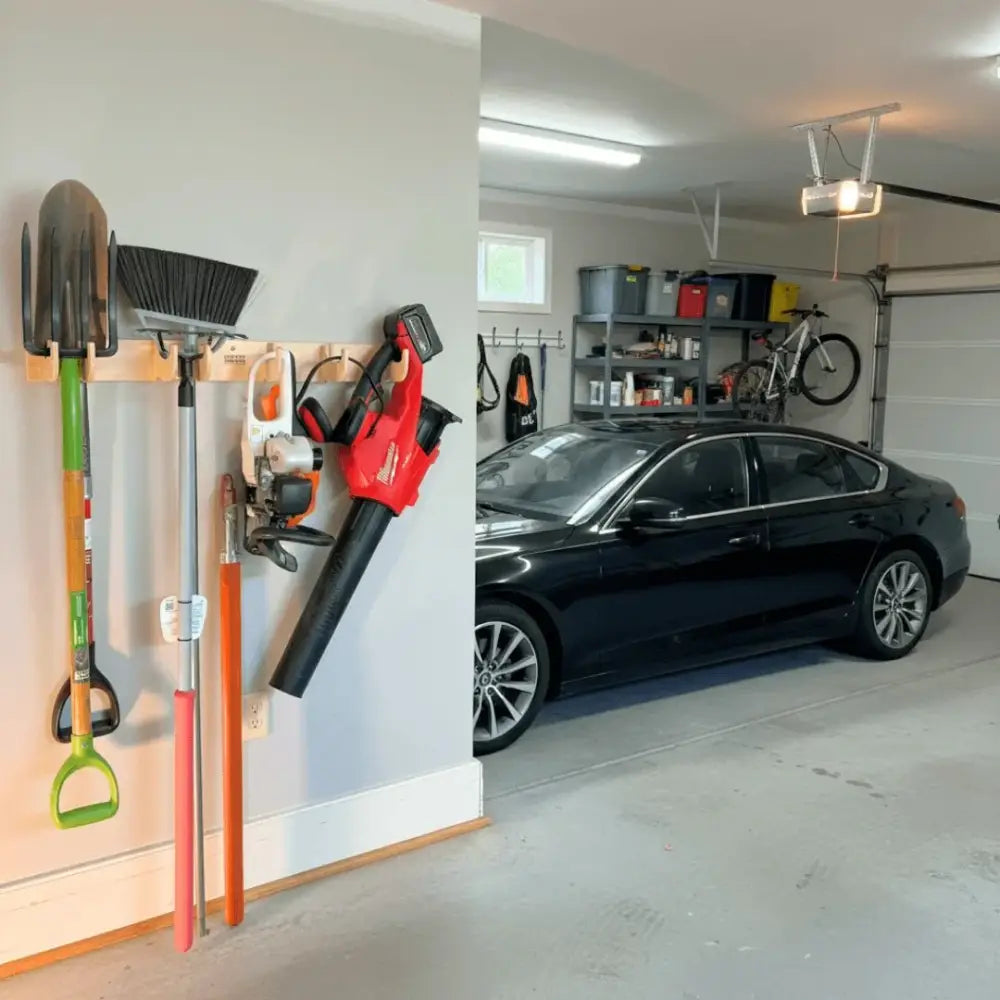 Red and black cordless leaf blower mounted on birch plywood heavy duty garage wall tool rack for organized storage