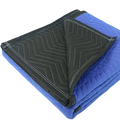 Heavy duty moving blanket showing blue quilted front with black zigzag stitched underside and white edge stitching