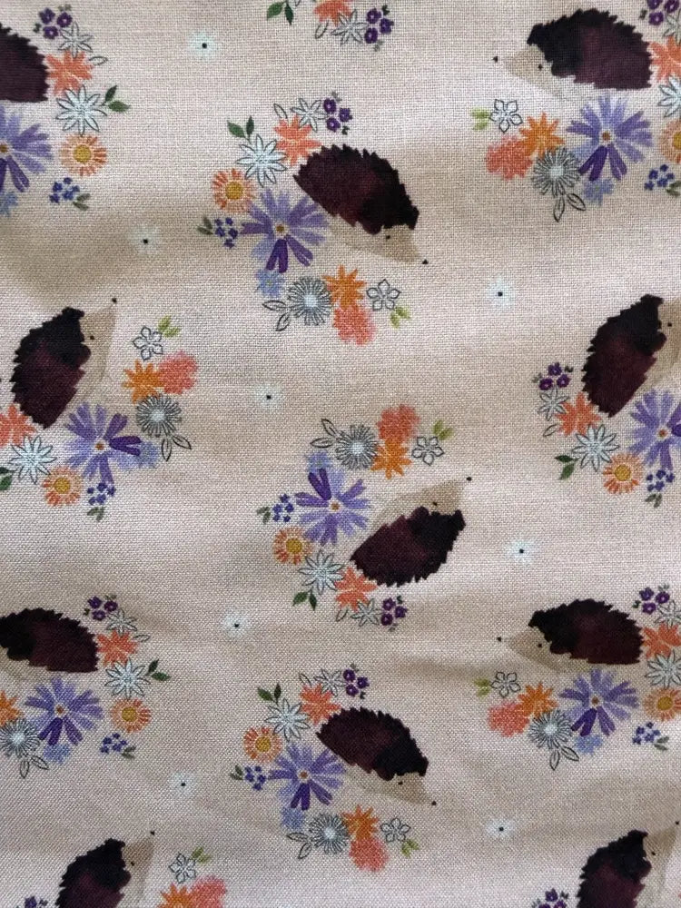 Beige cotton bow blouse featuring a vintage print of colorful flowers and dark brown hedgehogs pattern