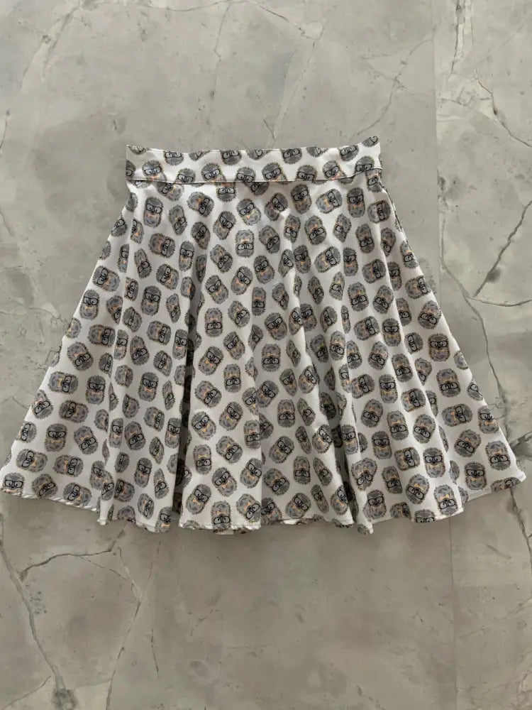 White cotton pleated retro hedgehog print skater skirt with repeating black and gray cartoon faces pattern