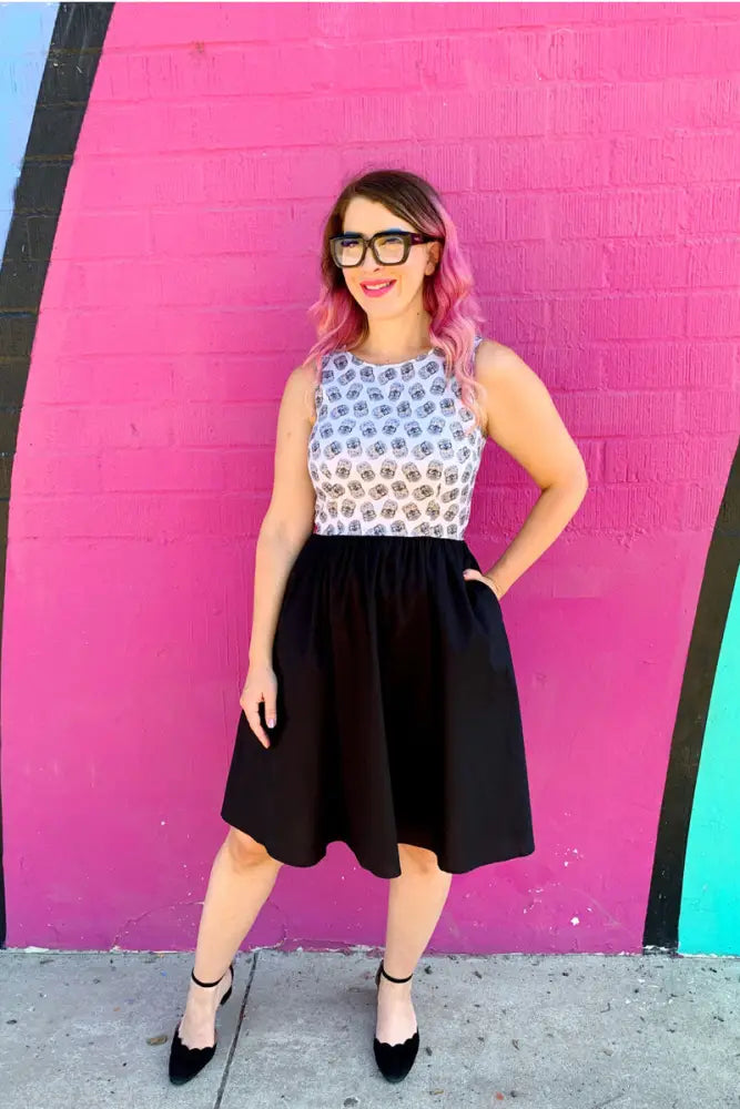 A woman wearing a vintage hedgehog print cotton twofer dress with sleeveless geometric top and black a-line skirt