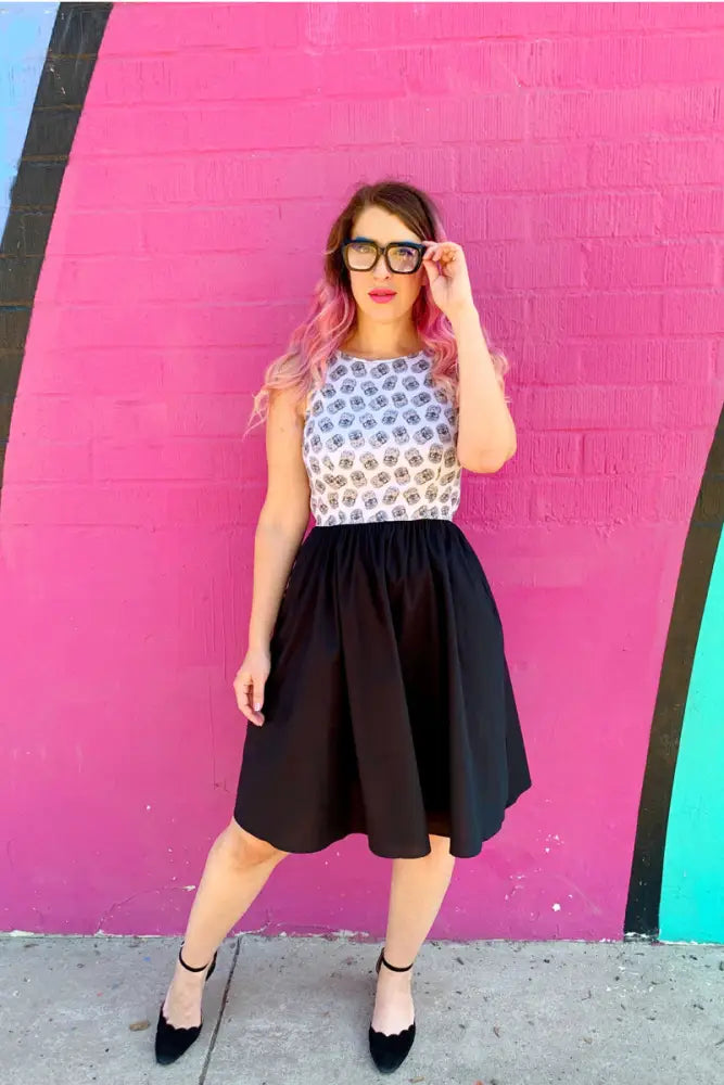 A woman wearing a vintage hedgehog print cotton twofer dress with a black and white patterned top and full black skirt