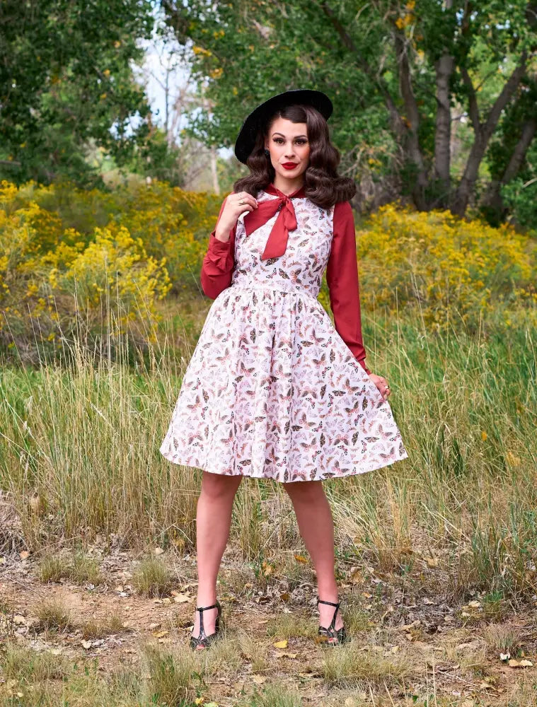 Helen retro bow tie blouse in cognac featuring a vintage white dress with delicate feather print and red long sleeves
