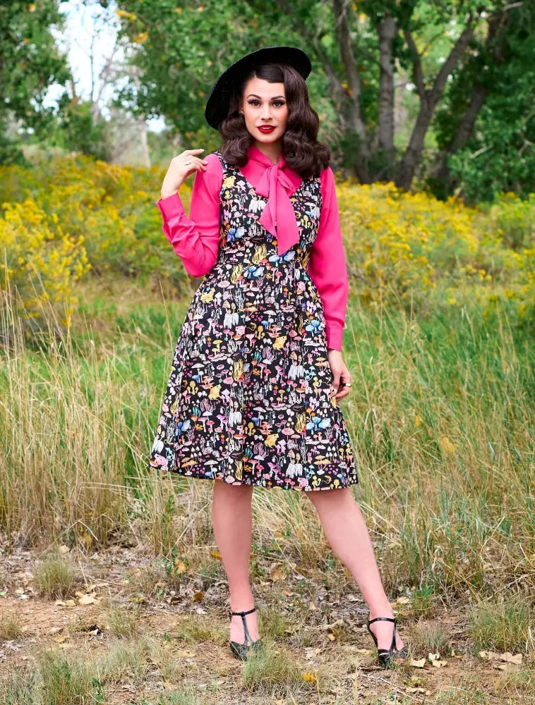 Helen pink bow tie retro long sleeve blouse worn under a black dress with colorful mushroom and fairy print