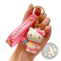 Pink silicone hello kitty cartoon keychain with white character wearing pink accessories holding a lollipop bag charm