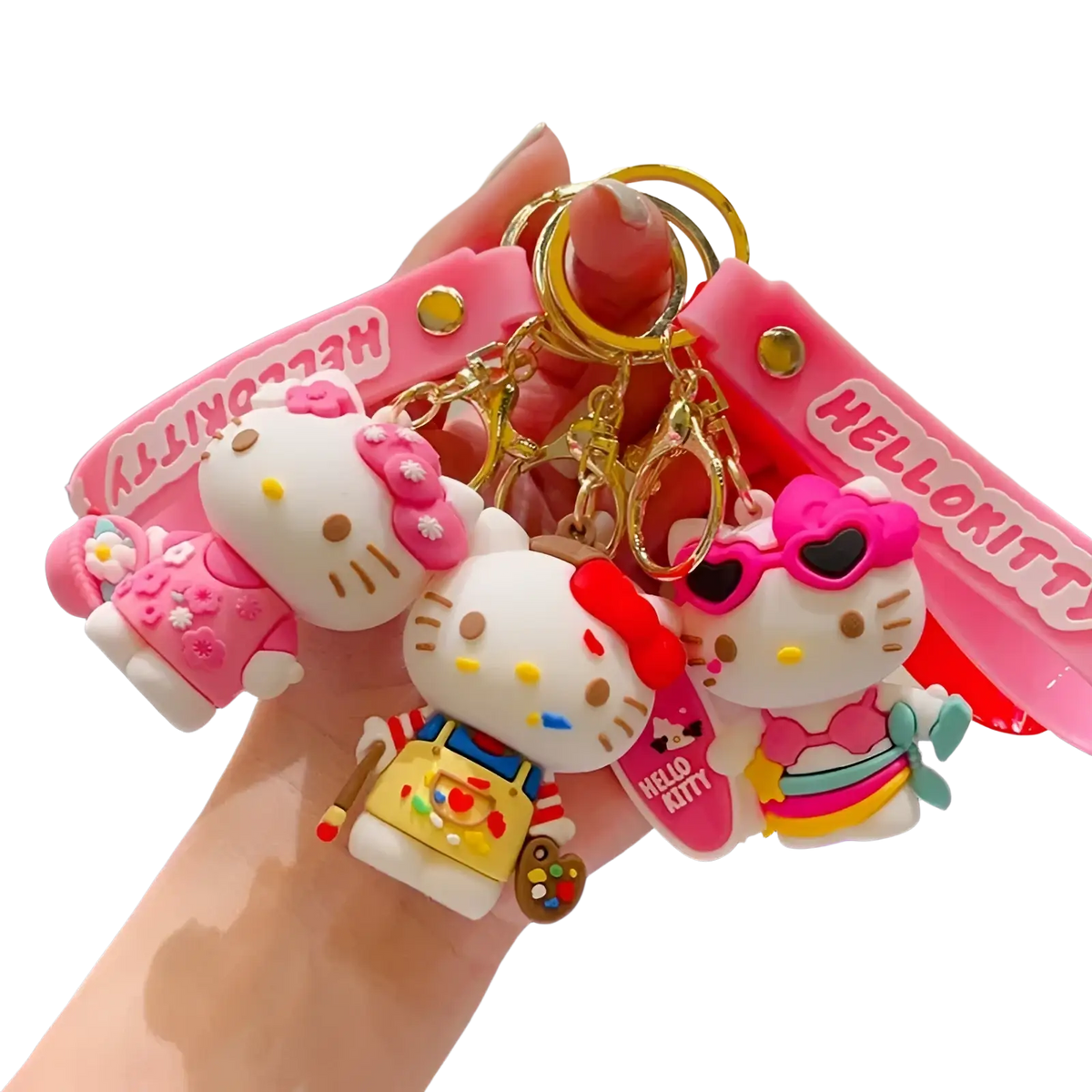 A set of three pink and white hello kitty cartoon keychains with unique outfits like painter apron and sunglasses