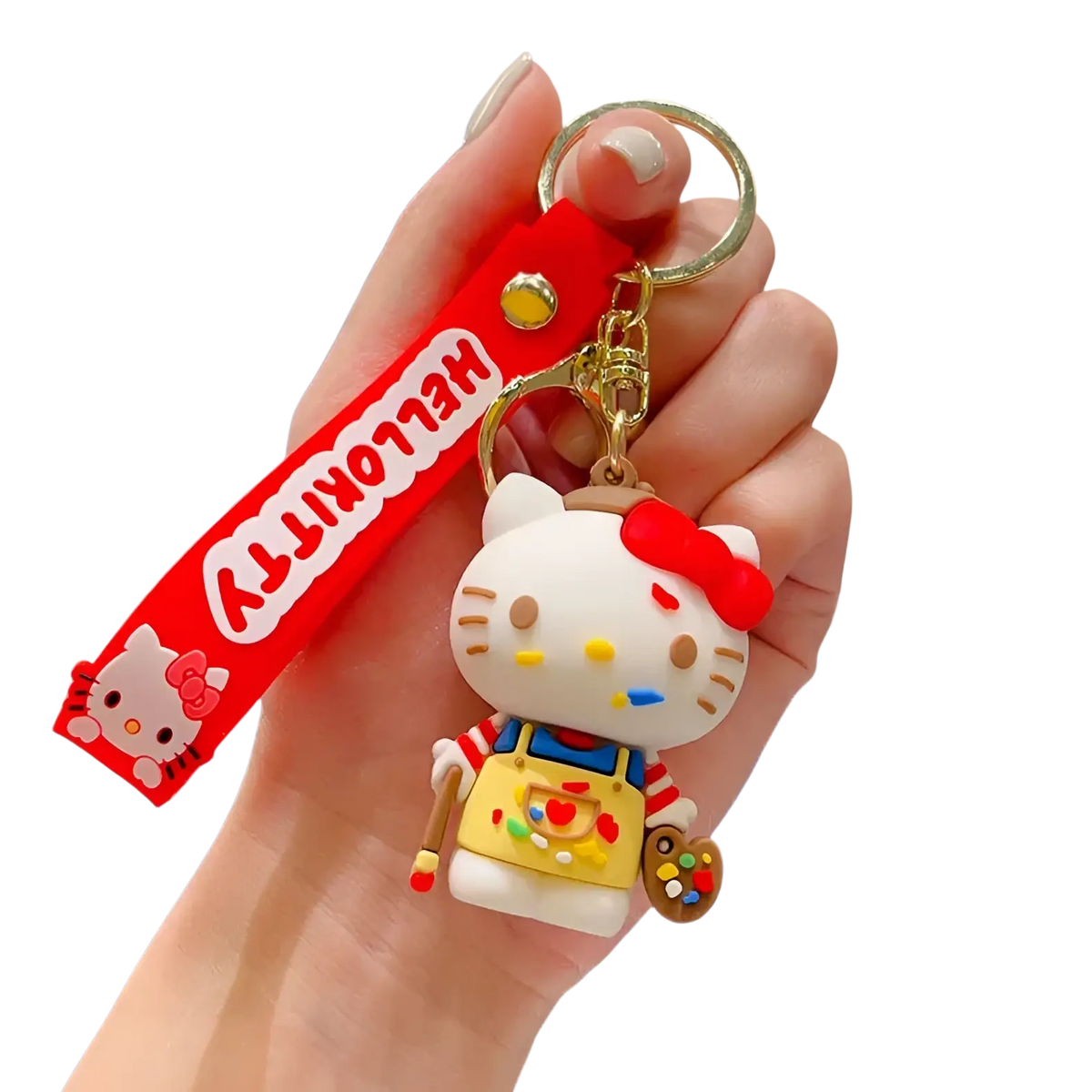 Hello Kitty cartoon keychain featuring a white figure with red bow, yellow overalls, and paintbrushes bag charm