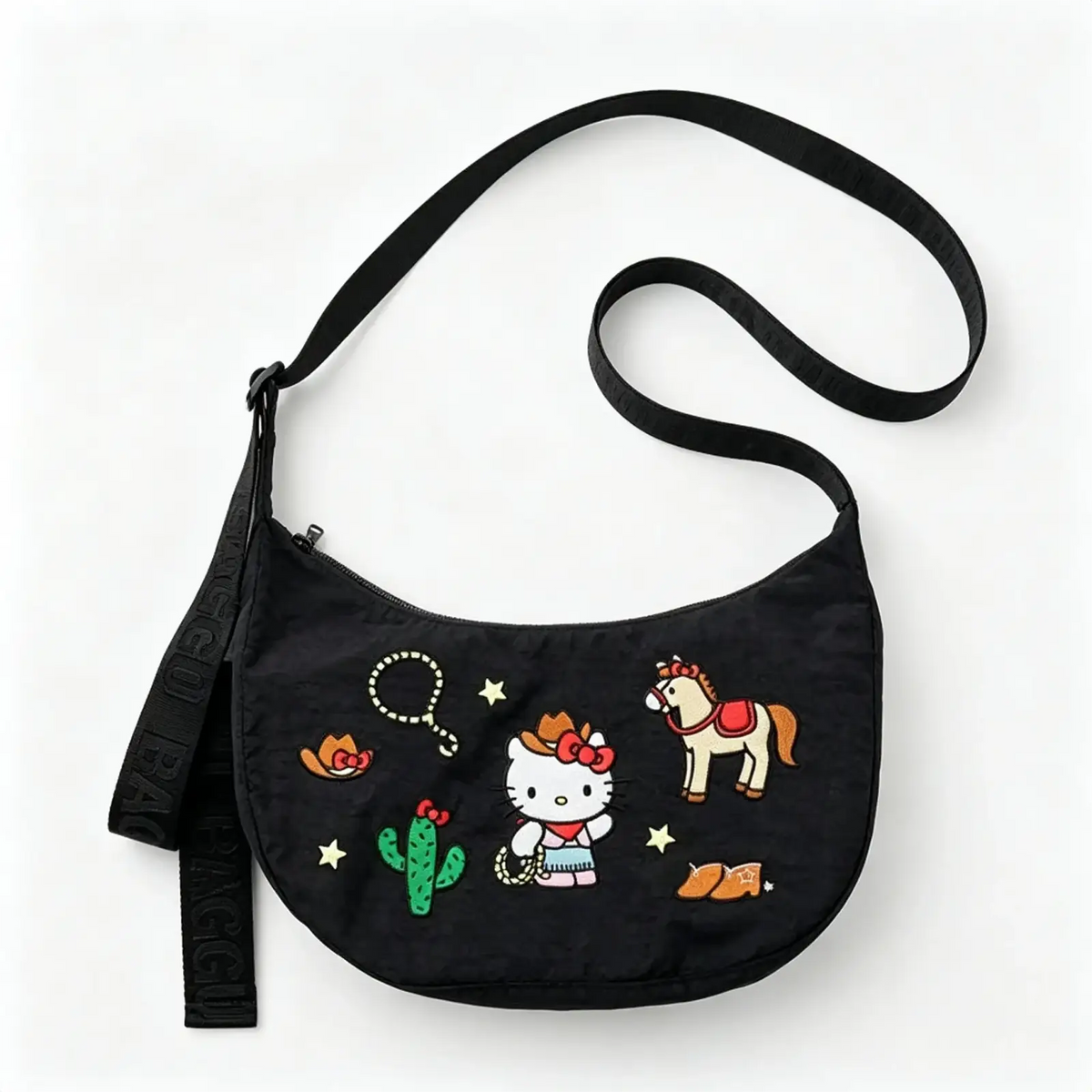 Black hello kitty dumpling crossbody bag with embroidered western designs featuring cowgirl hello kitty and cactus