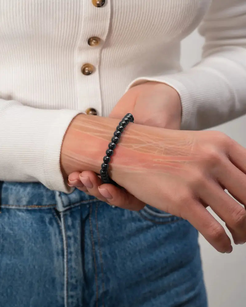 Black beaded high power 6mm magnetic hematite bracelet with steel charm worn on wrist