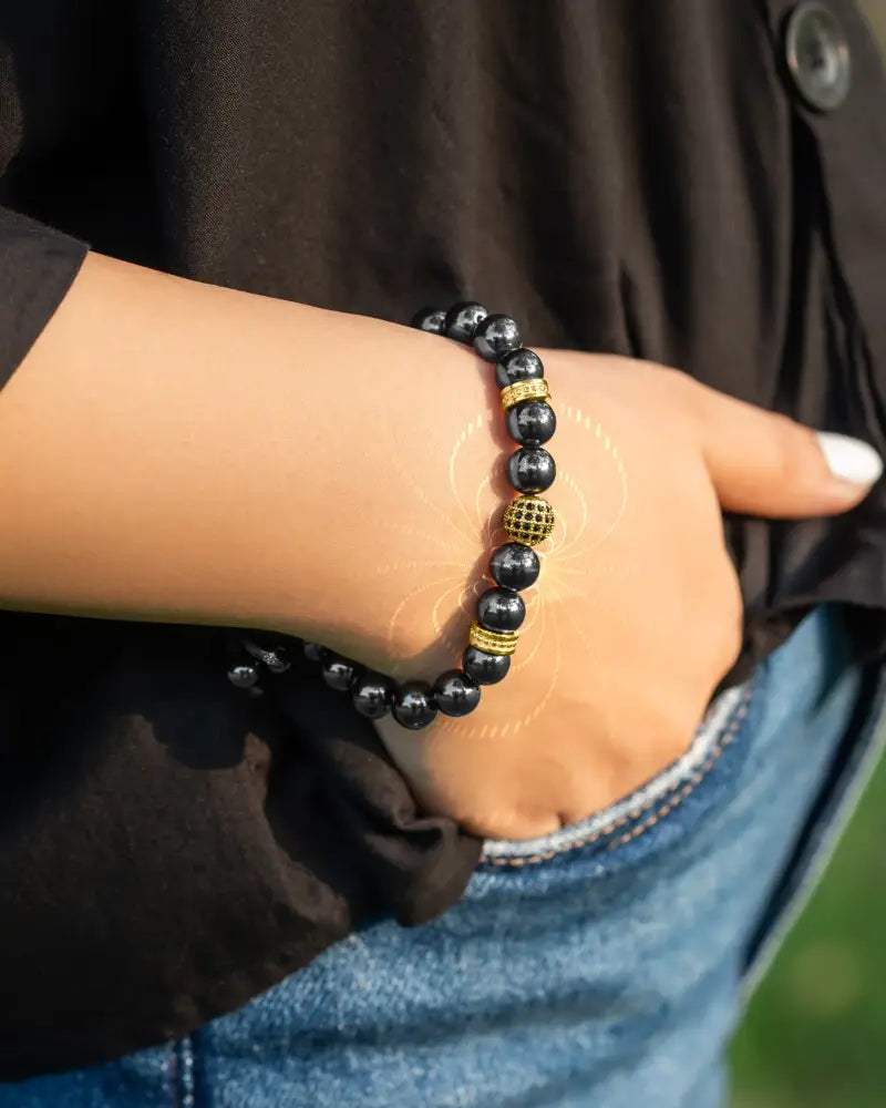 Black beaded gold zeus magnetic hematite bracelet with gold-toned accent beads and textured central bead