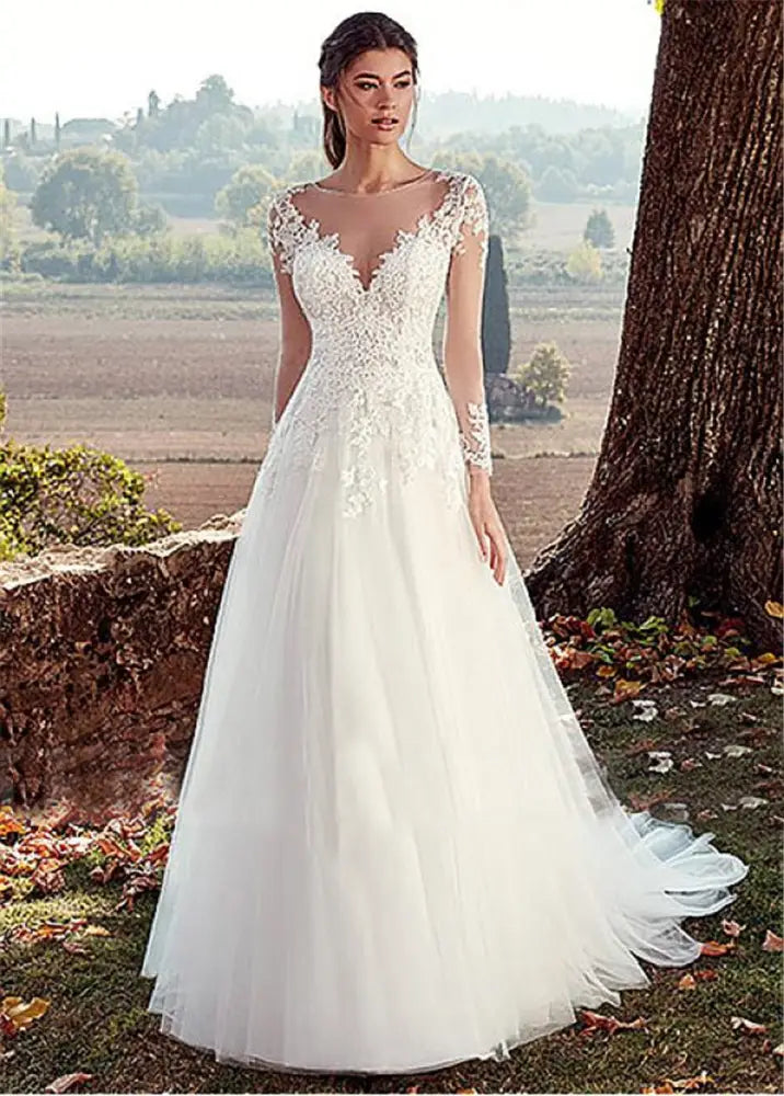 A flowing white lace long sleeve a-line tulle wedding gown with intricate bodice detailing and a v-neckline