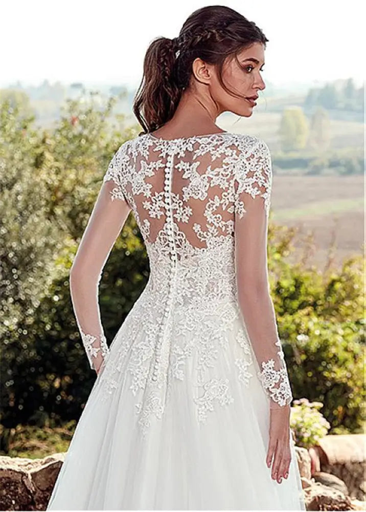White lace long sleeve a-line tulle wedding gown showing back with sheer floral embroidered detail