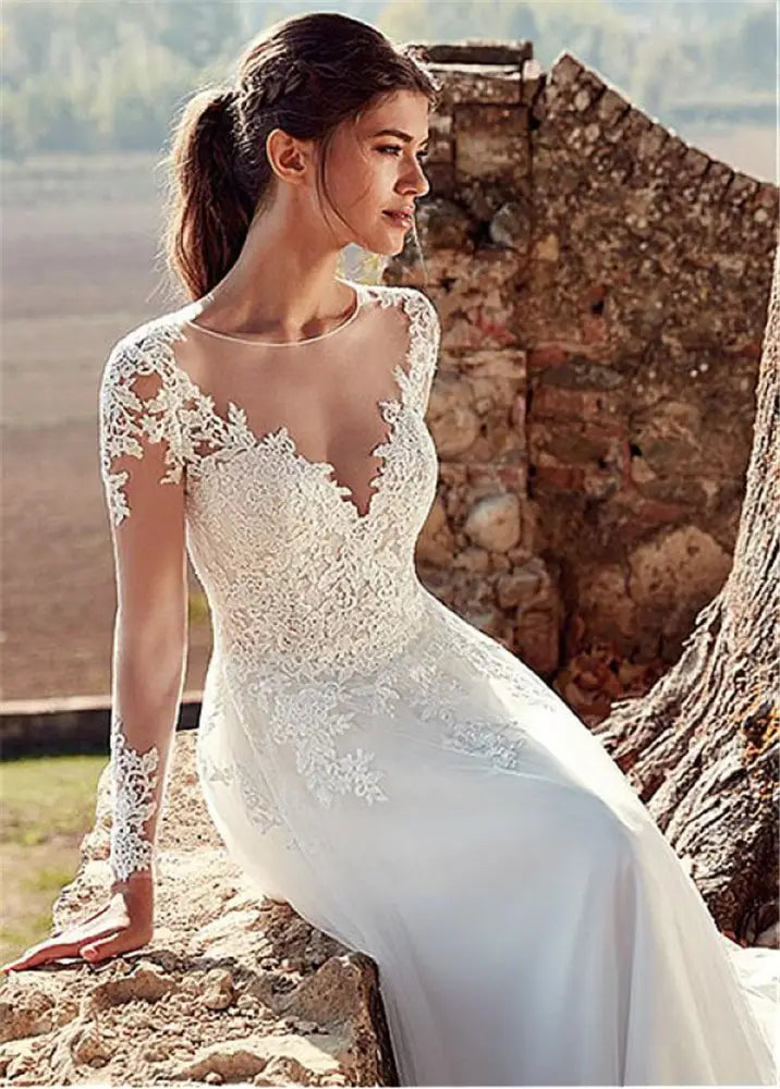 A white lace long sleeve A-line tulle wedding gown with v-neckline and intricate floral embroidery on bodice and skirt