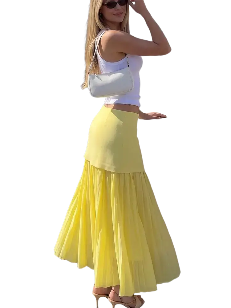 A white structured shoulder bag with a sleek design and thin strap paired with a high waist pleated long skirt