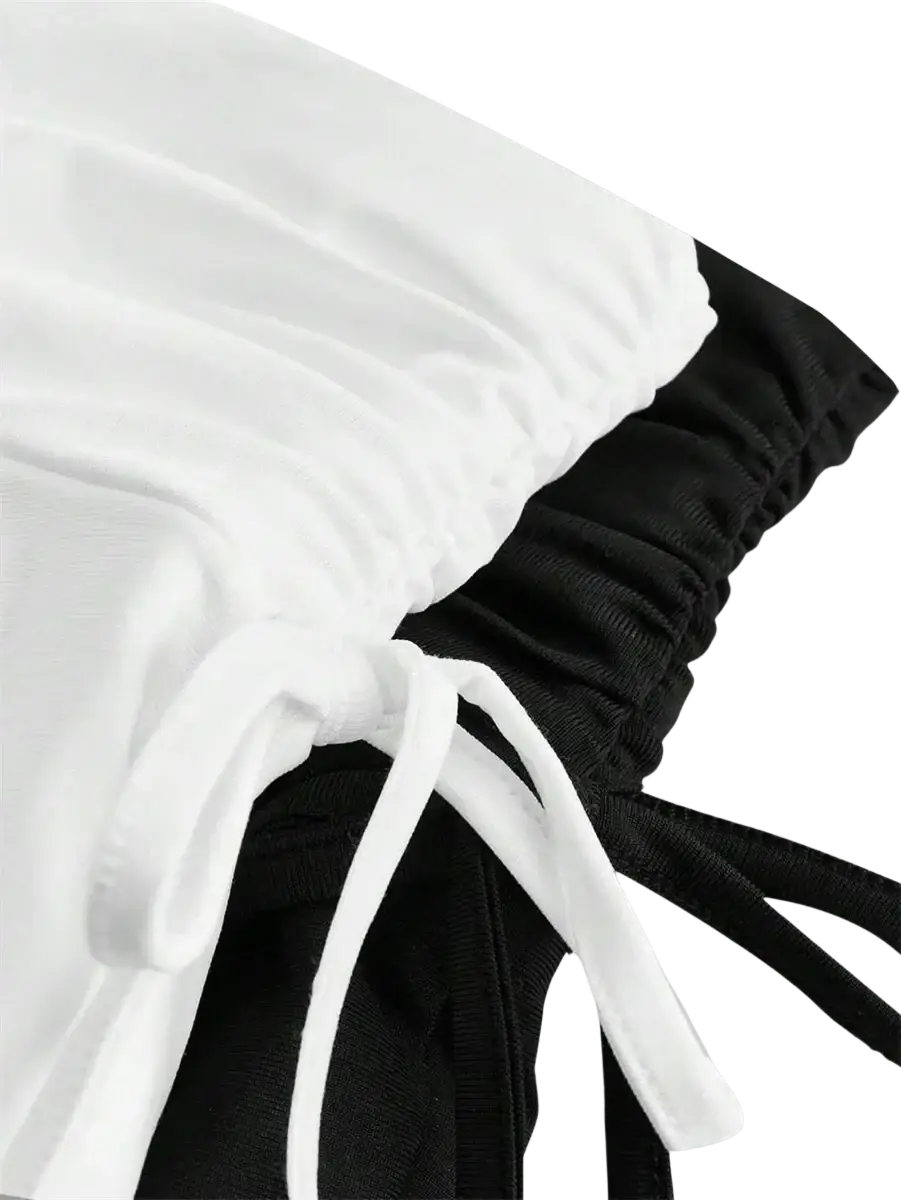 White and black drawstring pants with elastic waistbands shown from the back paired with high waist ruffle skirt