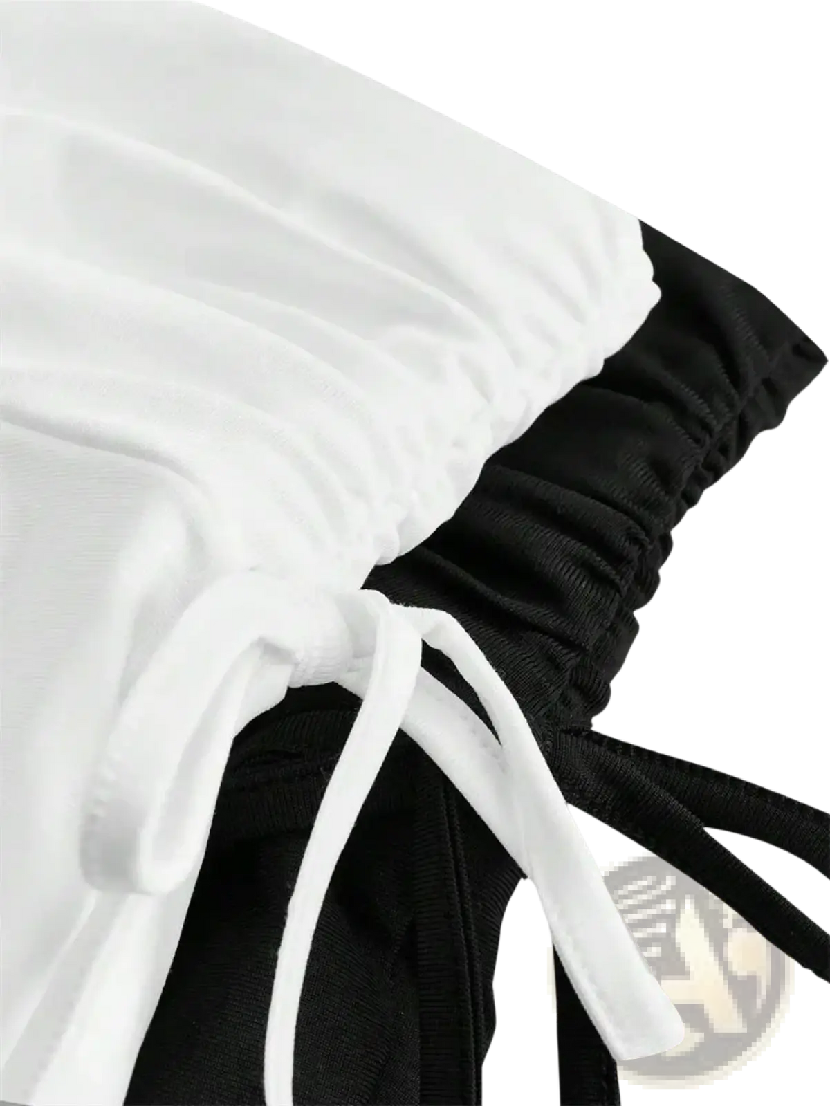 White and black drawstring pants with elastic waistbands shown from the back paired with high waist ruffle skirt