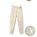 Cream-colored high waisted loose denim carrot pants with relaxed fit and rolled cuffs hanging on wooden hanger
