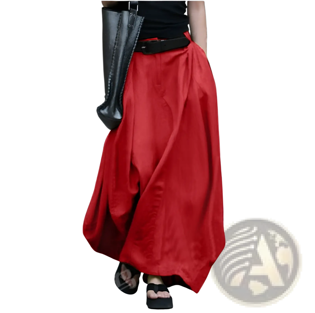 A flowing vibrant red high-waisted satin maxi skirt with a loose draped silhouette and a black belt at the waist