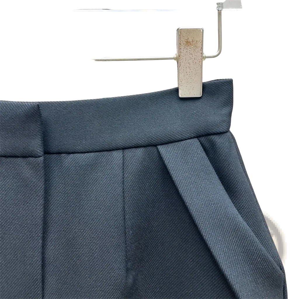Dark gray high waisted straight pencil skirt with structured waistband hanging on clear plastic hanger