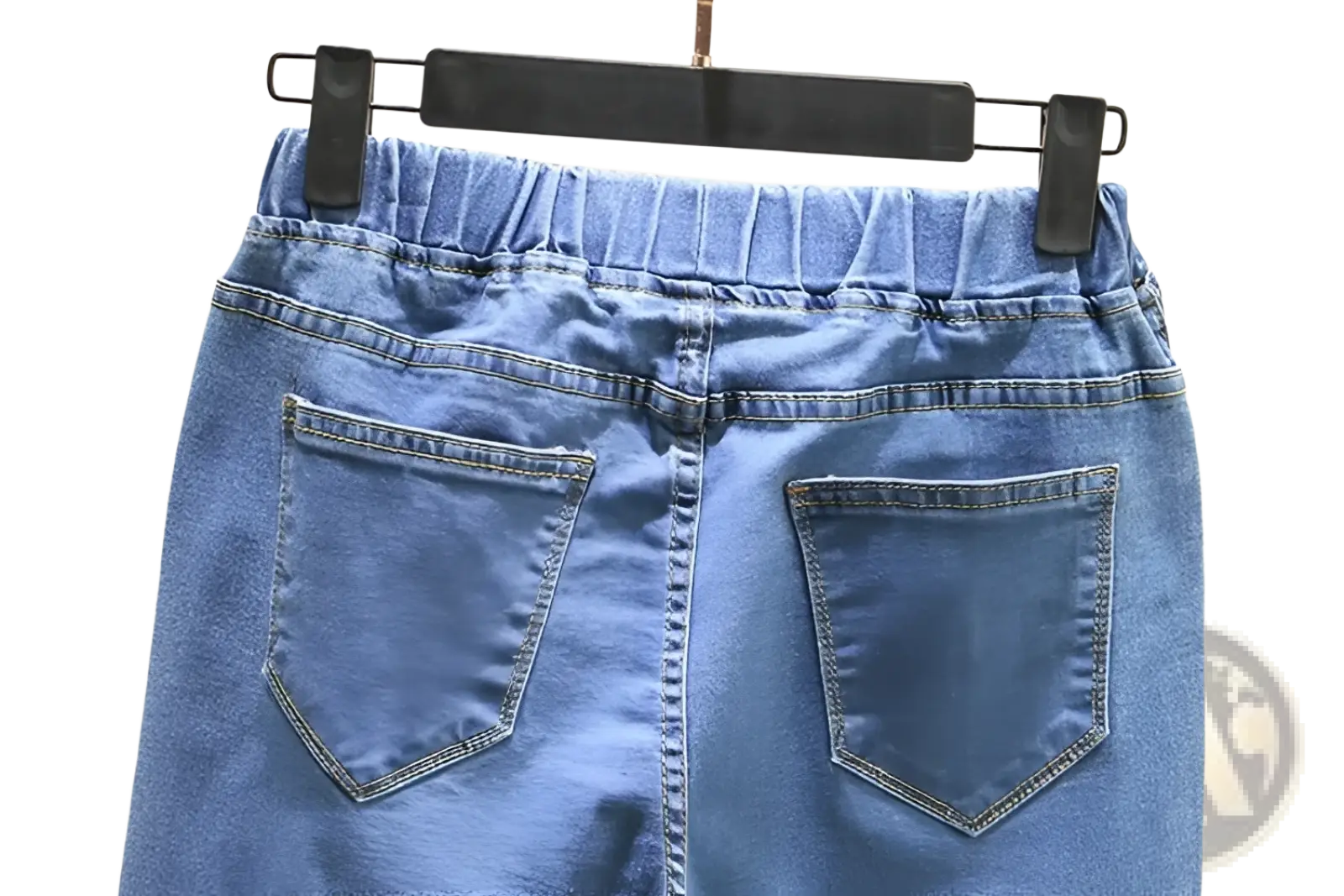 Back view of high waisted stretch light blue denim skirt with elastic waistband and two back pockets