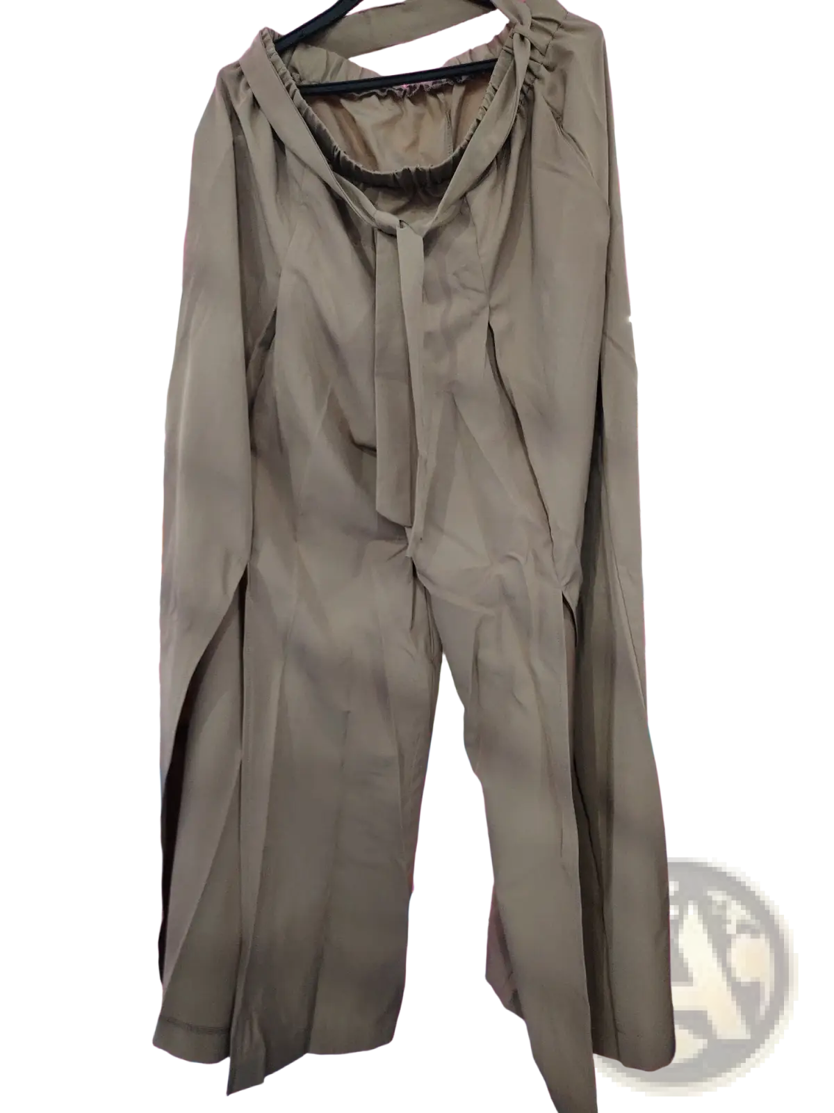 Beige high-waisted wide-leg pants with a drawstring waist and long sleeves hanging on a black hanger