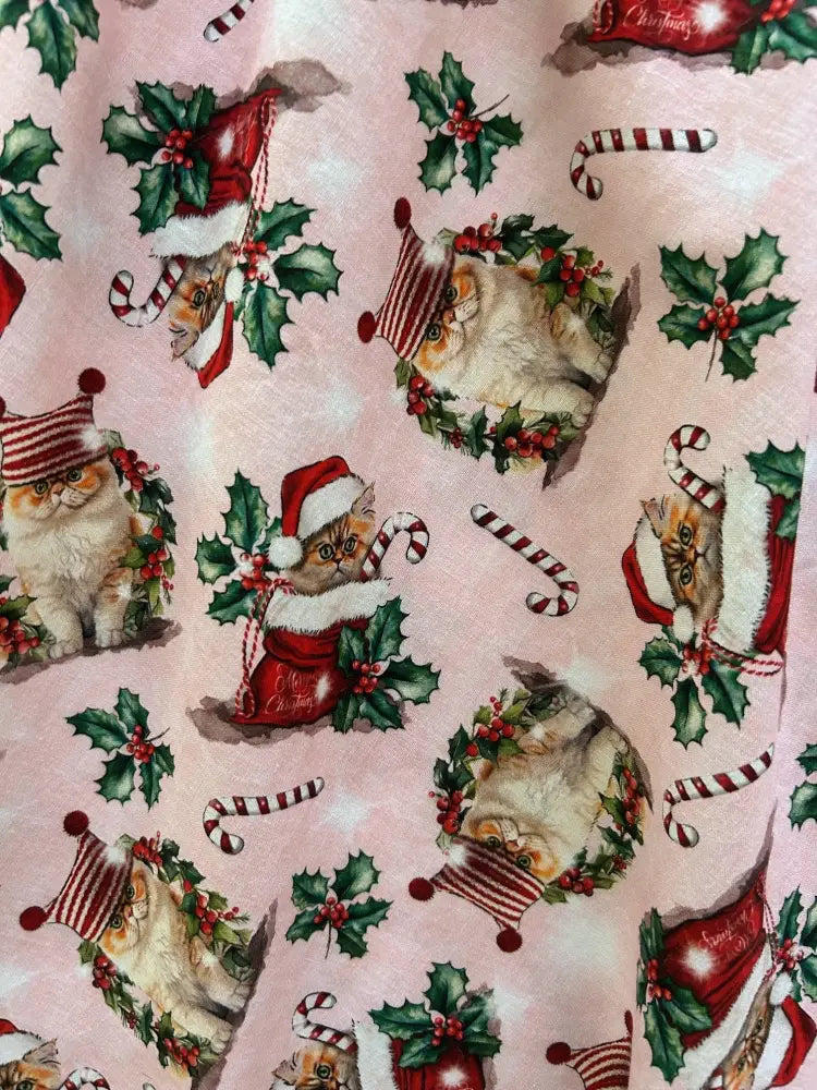 Pink cotton 1950s vintage midi dress featuring holiday cat pattern with santa hats and festive decorations
