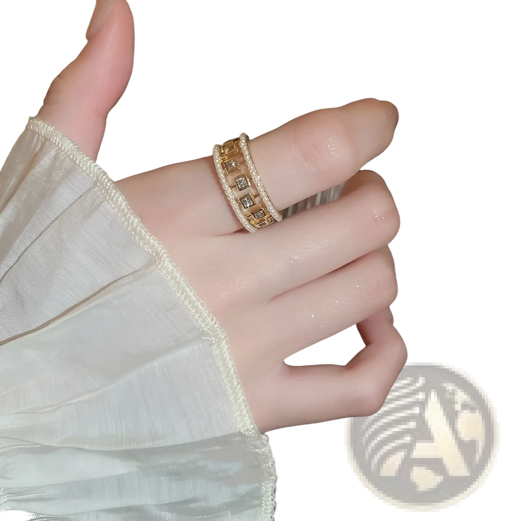 A gold-toned hollowed square pearl and baguette zircon open ring with wide band, square-cut stones, and beaded edges