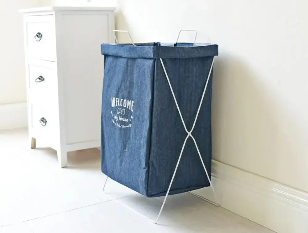 Blue denim laundry hamper with white metal frame and welcome to my house embroidered text for home use