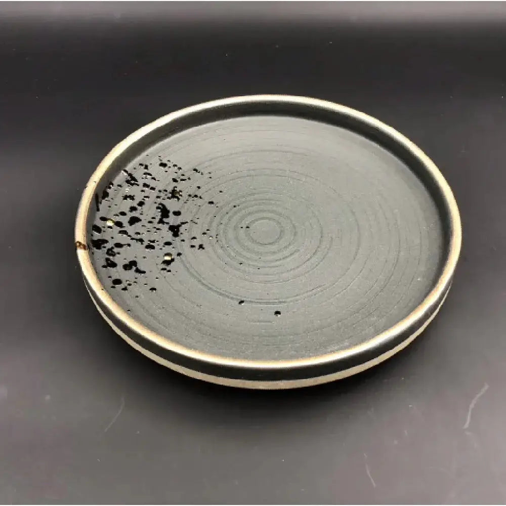 Minimalist Japanese ceramic speckled tableware set featuring a sleek dark gray plate with concentric rings and beige rim