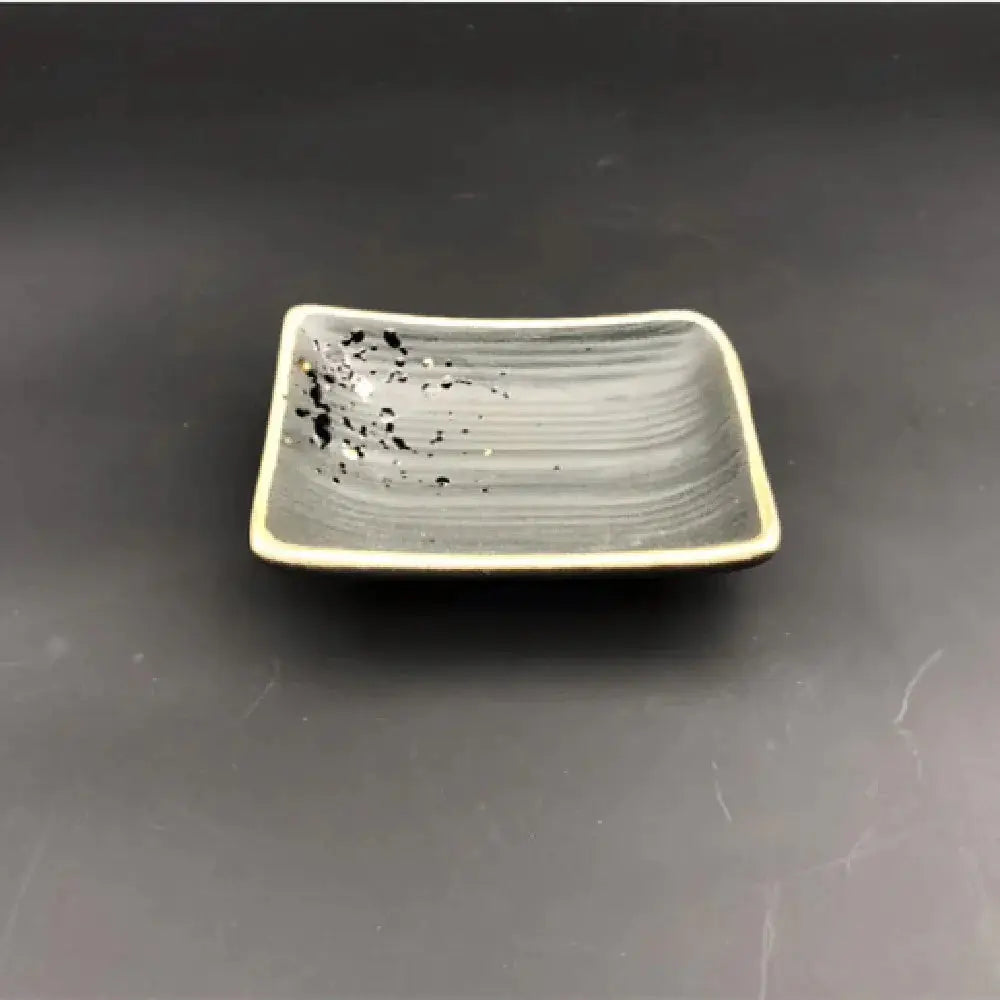 Gray ceramic rectangular dish with subtle horizontal ridges and black speckles from minimalist Japanese speckled tableware set
