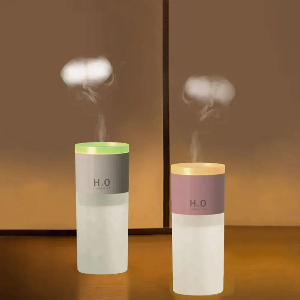 Two portable usb led mist humidifiers and aroma diffusers with green and beige tops emitting mist