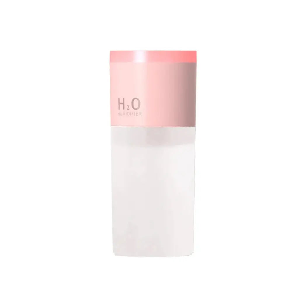 A sleek translucent white portable USB LED mist humidifier and aroma diffuser with a soft pink cap and minimalist h₂o branding