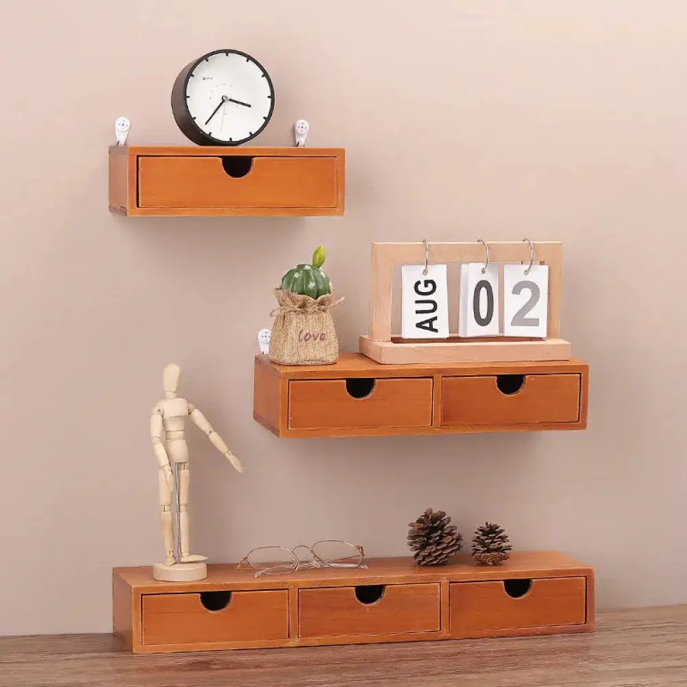 Set of three floating retro lockable wooden storage drawers with black circular handles in a tiered display