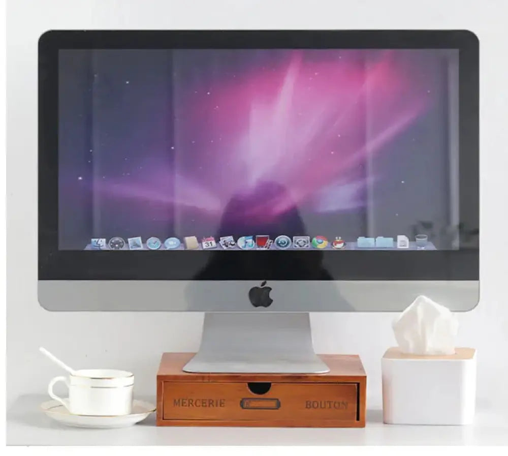 Silver aluminum apple imac desktop with a sleek design and purple aurora wallpaper alongside a retro lockable wooden storage box with vintage drawers