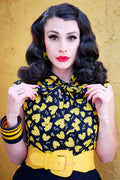 Yellow leather belt with prominent rectangular buckle paired with honey hives vintage 1950s cotton bow top