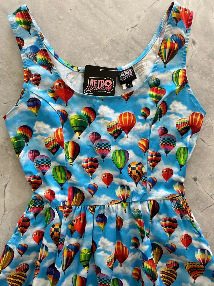 A vibrant blue cotton fit and flare sleeveless dress with a multicolored vintage hot air balloon print