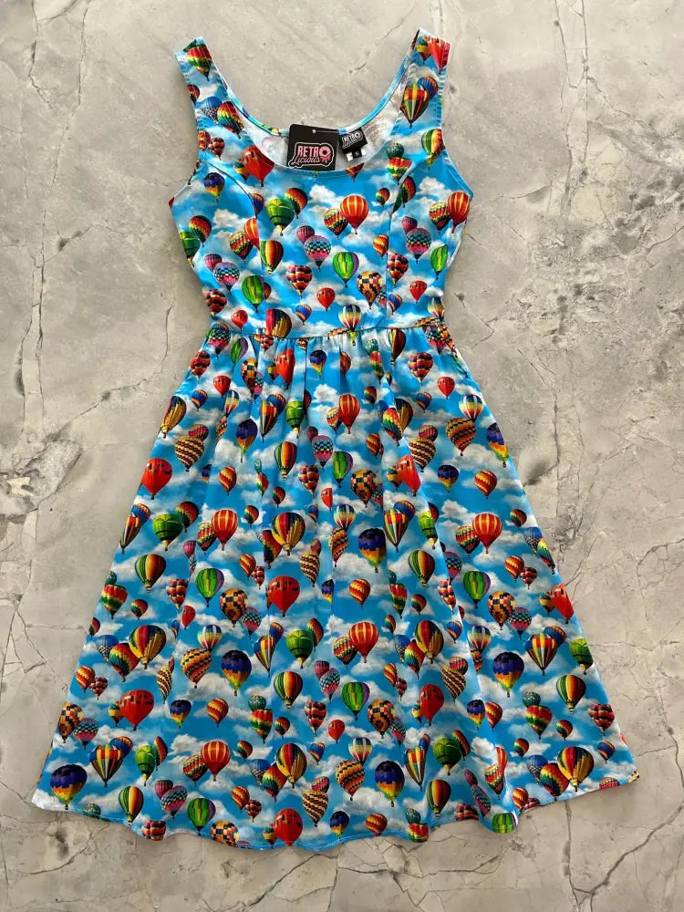 A vibrant blue cotton vintage hot air balloon print sleeveless fit and flare dress with a fitted bodice and flared skirt