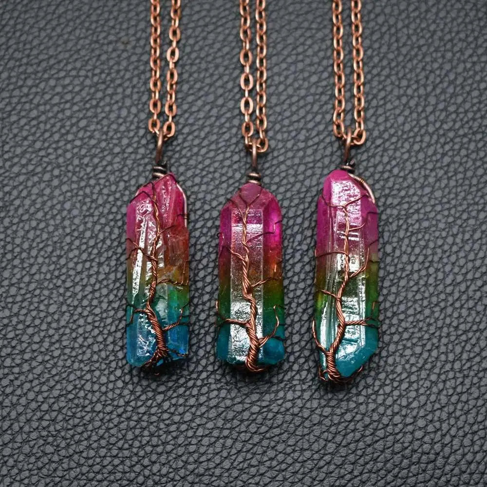 Three rainbow-colored crystal pillar pendants with copper wire-wrapped tree of life design and matching chains