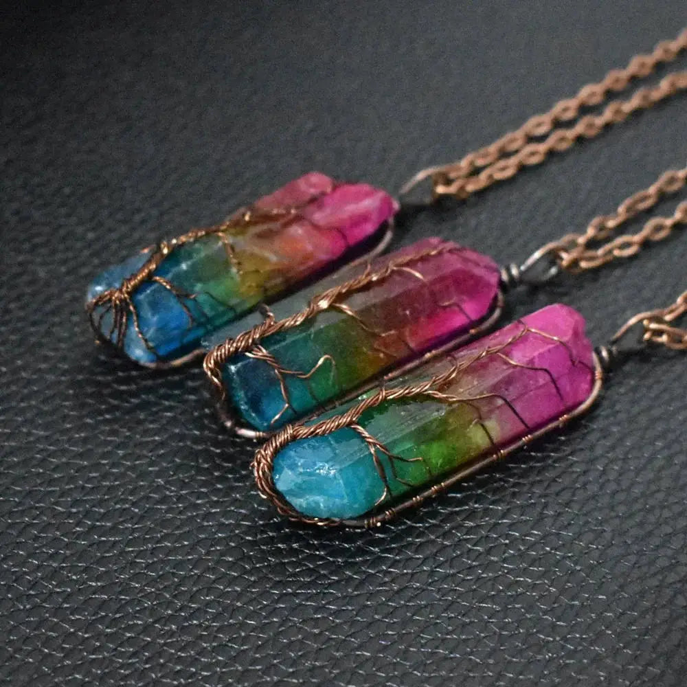 Three rainbow-colored crystal pillar pendant necklaces with copper wire wrapping on gold-toned chains